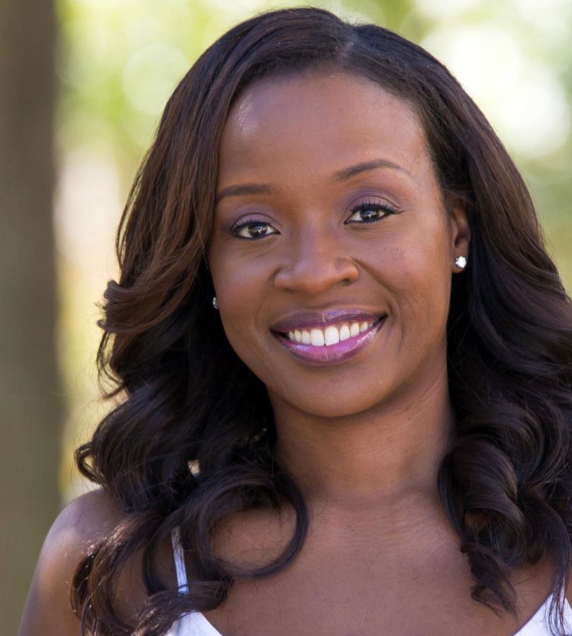 Portrait of Jeannette Bayardelle, smiling, outdoors in soft natural light.